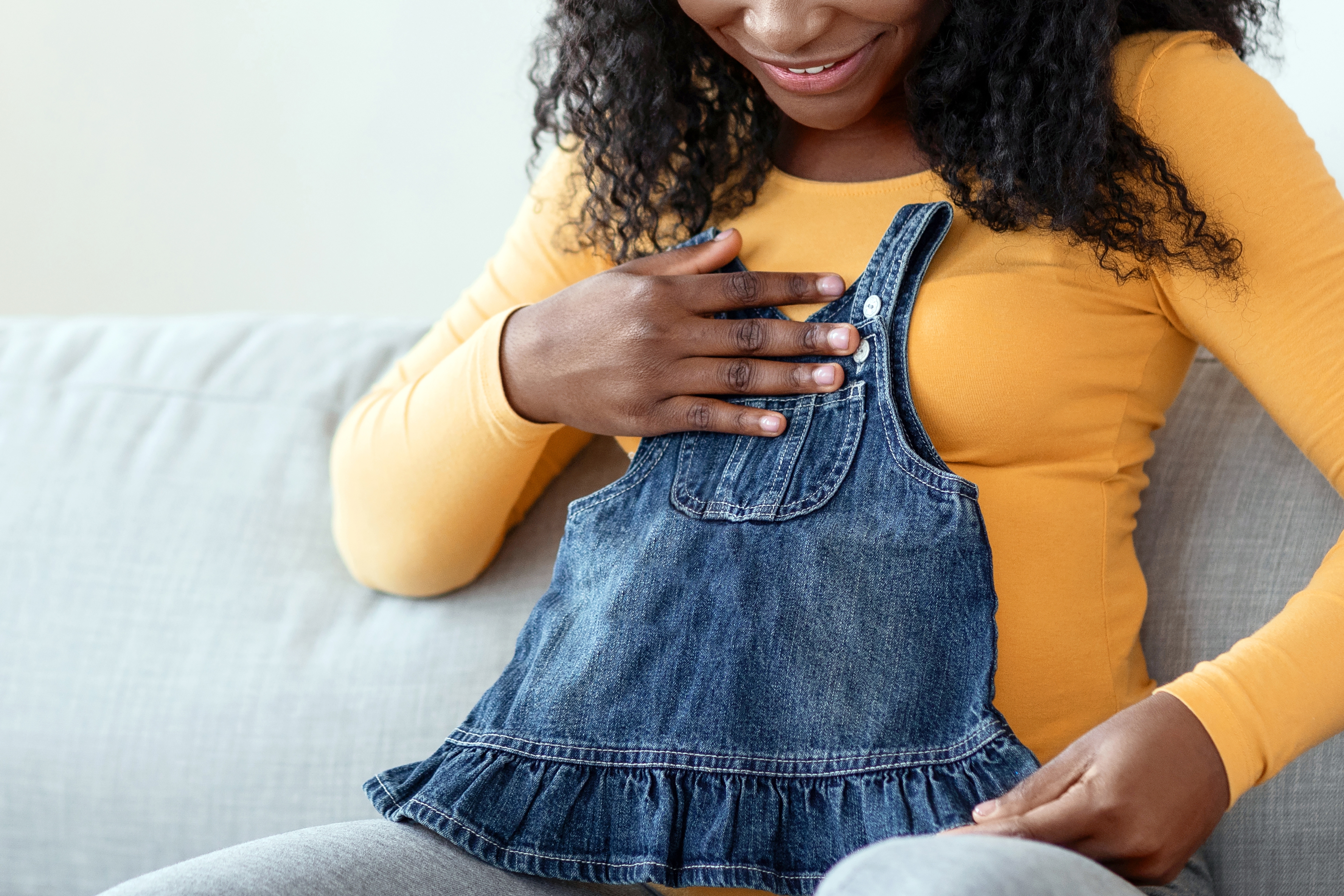 Happy,Pregnant,Black,Woman,Sitting,On,Sofa,With,Notebook,And