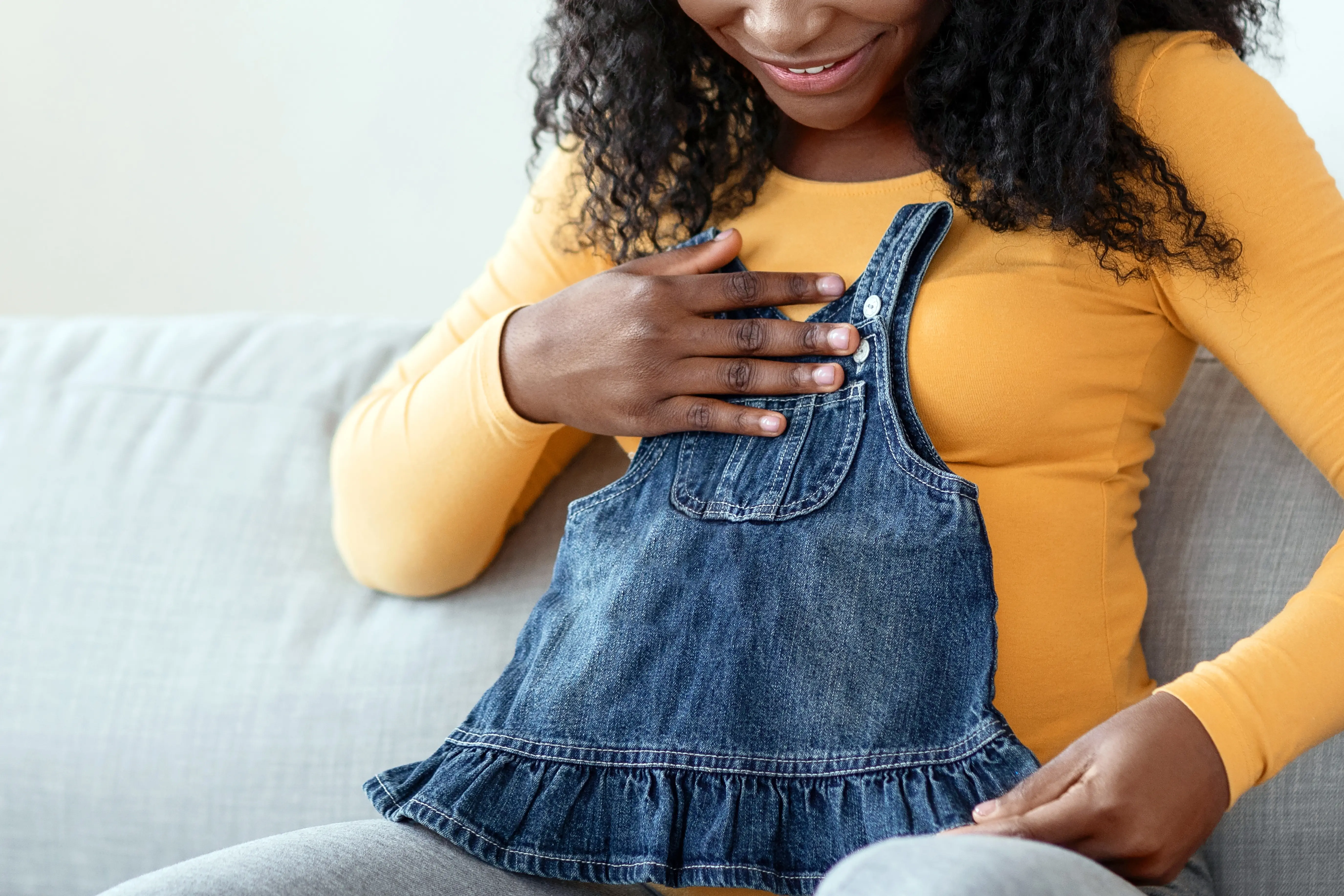 Happy,Pregnant,Black,Woman,Sitting,On,Sofa,With,Notebook,And