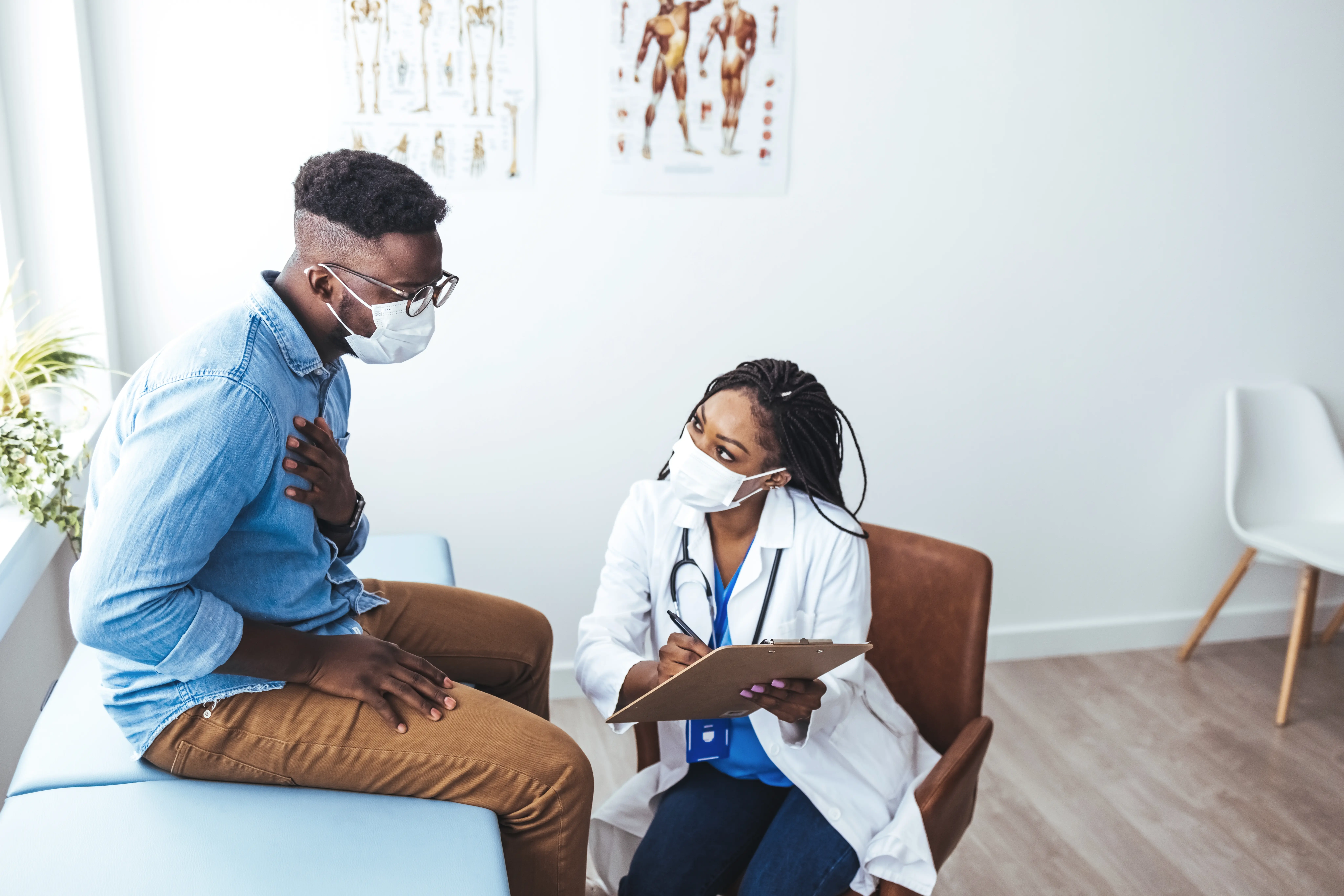 Black,Female,Doctor,Communicating,With,A,Patient,While,Wearing,Protective